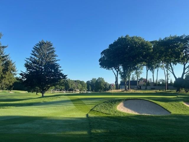Golf course fairway with bunker and trees